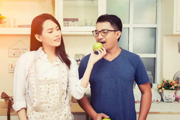 Gelukkige paar eten verse appel. Plezier in de keuken. — Stockfoto