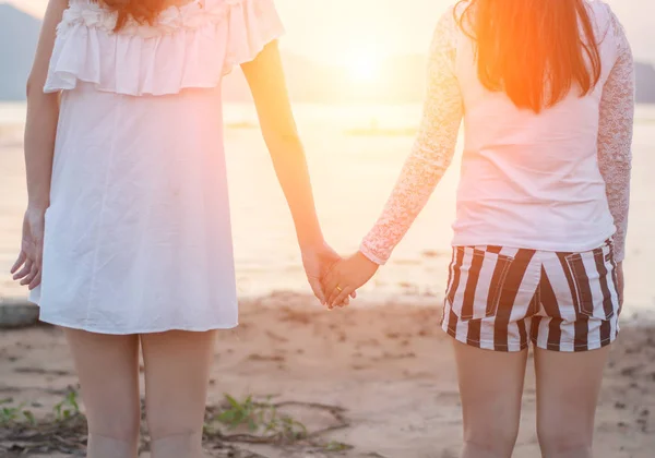 Dvě mladé ženy drží ruce společně na moře — Stock fotografie