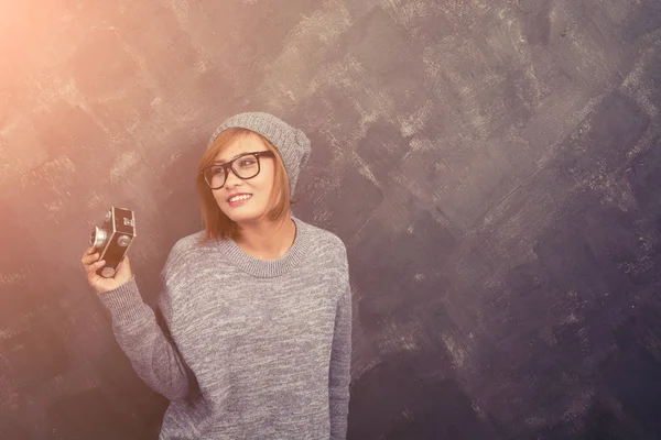Mosolyogva csípő nő szemüveg gazdaság egy kamera retro aga — Stock Fotó