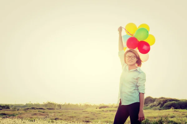 Mulher bonita de pé segurando colorido de balões em t — Fotografia de Stock