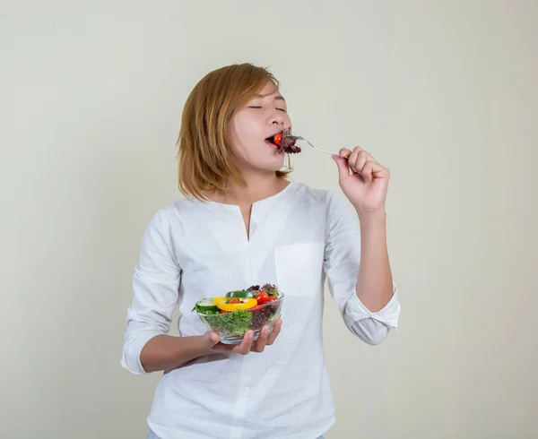 Hermosa mujer de pie sosteniendo tazón de ensalada comiendo un poco de vegeta —  Fotos de Stock