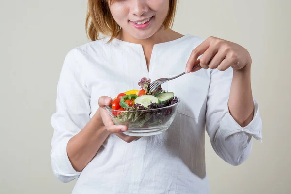 Gyönyörű nő állandó üzem eszik néhány hálók zöldség saláta tál — Stock Fotó