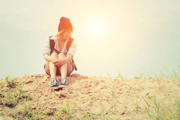 流行に敏感な若い女性、砂の上に座って、バックパックの fe — ストック写真