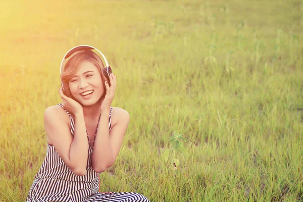 Hermosa mujer sexy sentada escuchando música desde los auriculares smi — Foto de Stock