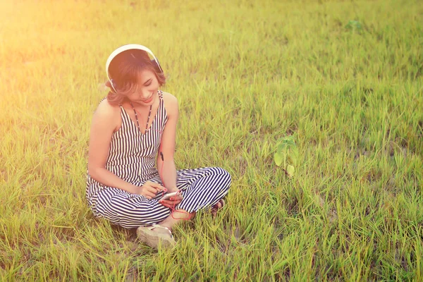 Beautiful sexy woman sitting  listening music from headphone smi — Stock Photo, Image