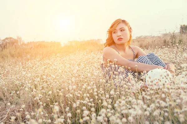 Sad woman sitting in flower field and loneliness — Stock Photo, Image
