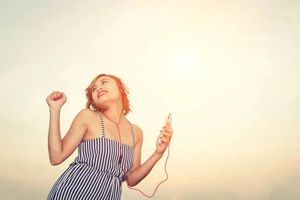 Schöne sexy Frau hört Musik vom Smartphone im Fluss — Stockfoto
