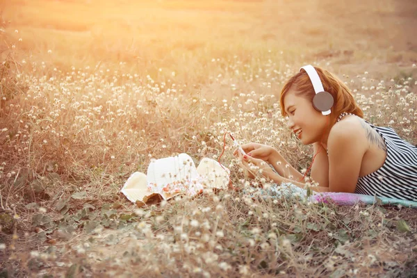 Beautiful Sexy Woman with Headphones Outdoors in the flower fiel — Stock Photo, Image