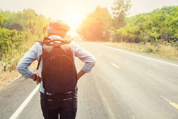 Vue arrière d'une jeune femme en stop sur route de campagne walki — Photo