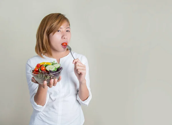 Piękna młoda kobieta za pomocą widelec zjeść pomidora w misce sala — Zdjęcie stockowe