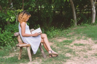güzel yalnız kadın oturuyordu bankta okuma.