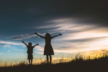 Anne oğlunu açık havada, günbatımı, siluet kavramı teşvik