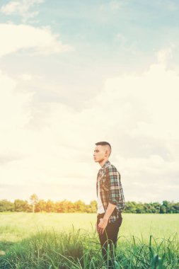 genç yakışıklı adam yeşil alana ayakta.