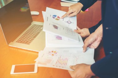 Bir rapordaki finansal verileri işaret eller takım profesyoneller, birlikte office ahşap masa başında çalışan kapatın.