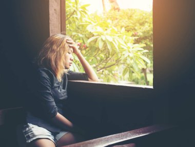 Kadın yaşam tarzı kavramı: tezgah besid üzerinde oturan genç üzgün kadın