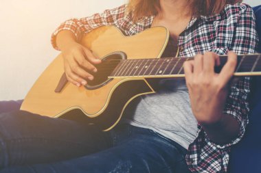 Genç hipster kadın bir gitar çalmak.