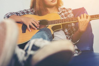 Genç hipster kadın bir gitar çalmak.