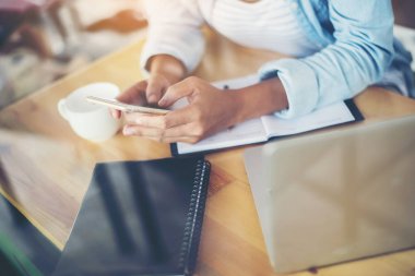 Elleri yumuşak kahve dükkanında smartphone kullanan yenilikçi kadın