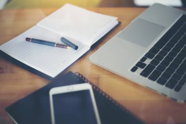 İş çalışma alanı ile ahşap masa üstünde laptop.