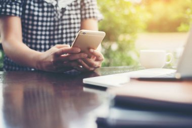 Elleri yumuşak kahve dükkanında smartphone kullanan yenilikçi kadın