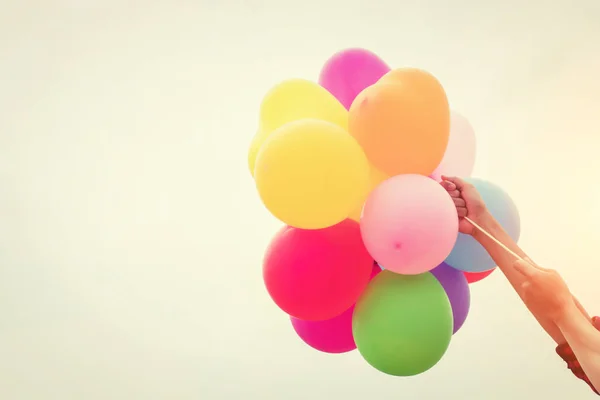 Hand van een tiener meisje houdt van kleurrijke ballonnen in de zon — Stockfoto