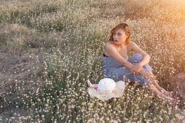 Sexy Mulher bonita sentada no campo de flores tristemente e solitários — Fotografia de Stock
