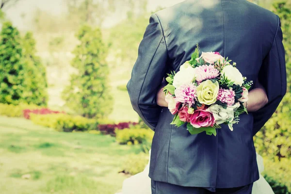 Mariée câlin marié et ses mains tenant bouquet dans la fête de mariage . — Photo