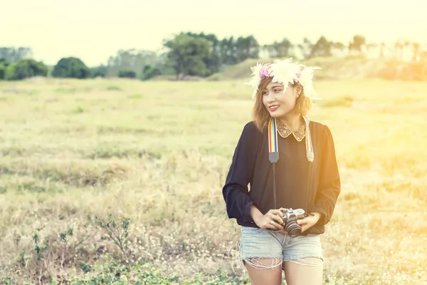 Hermosa sonrisa mujer en corona de flores con cámara retro en — Foto de Stock