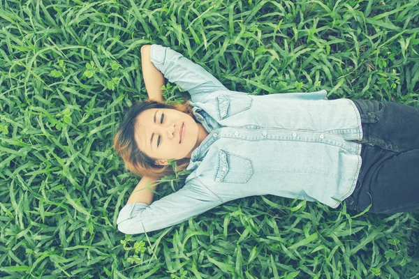 Junge Hipster-Frau legt sich auf Gras. — Stockfoto