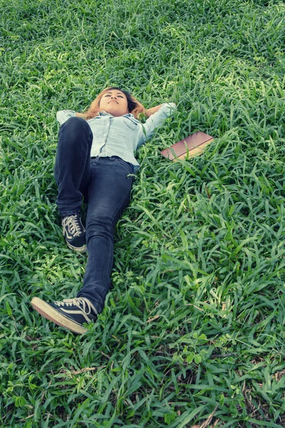 Junge Hipster-Frau legt sich auf Gras, als sie nach der Arbeit müde wird — Stockfoto
