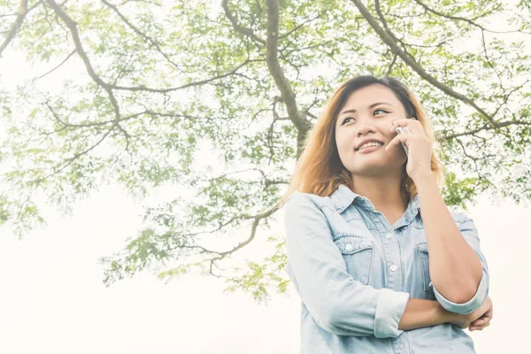 Jonge hipster vrouw praten in de mobiele telefoon in het park. — Stockfoto