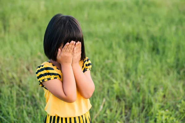 Niños niña traer sus manos cerró su cara y triste . —  Fotos de Stock
