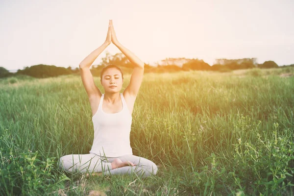 Joven yoga mujer sentarse meditación en los prados . —  Fotos de Stock