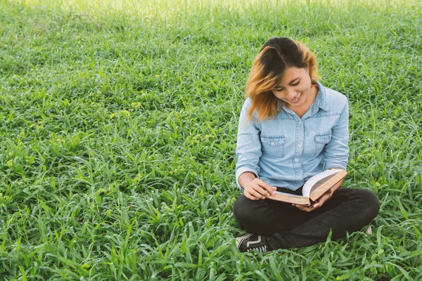 Žena, vzdělávání. Mladá krásná žena s knihou v parku — Stock fotografie