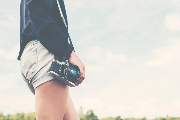 Красивые женщины фотографируются стоя, держа в руках ретро-камеру i — стоковое фото