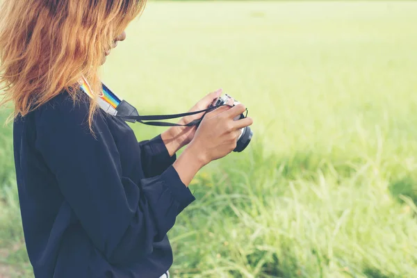 Mujer joven con cámara retro, estilo de vida hipster mirar su ret — Foto de Stock