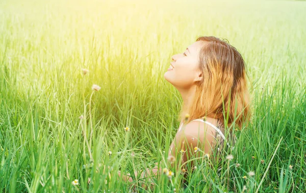 Junge schöne Frau sitzt auf der Wiese genießen die Natur und fres — Stockfoto