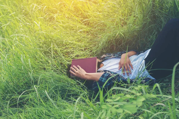 Jonge hipster man liggen op grasland dutten moe na re — Stockfoto