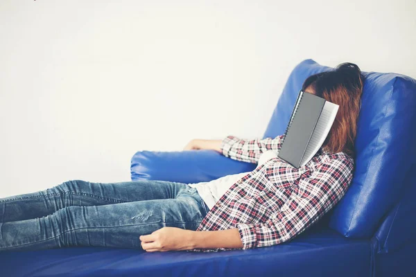 Jovem bela mulher dormindo no sofá azul cansado para escrever . — Fotografia de Stock