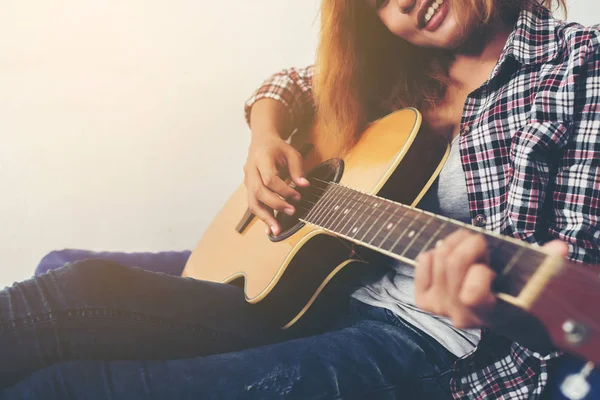 Genç hipster kadın bir gitar çalmak.