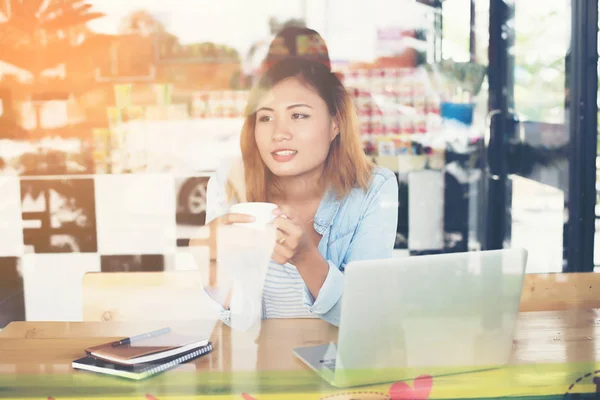 Joven mujer hipster sosteniendo una taza de café y trabajando un poco de wor — Foto de Stock