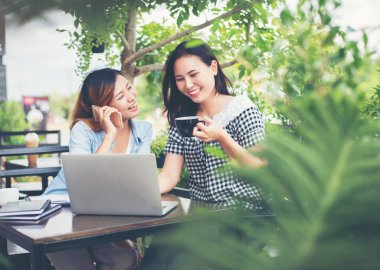 Birlikte bir kahve dükkanında çalışan zevk iki arkadaş gülen. 