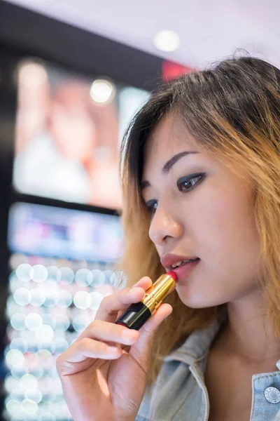 Beautiful young woman select color lipstick to buying at shoppin — Stock Photo, Image
