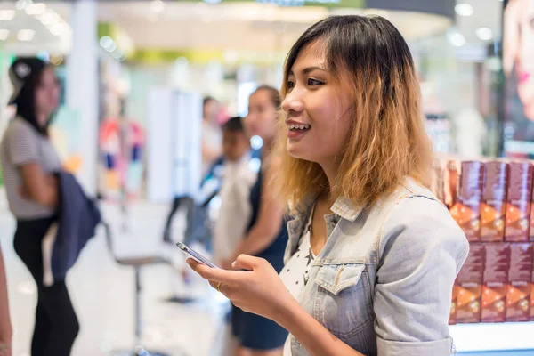Ung vacker kvinna som bär jean jacka textning på smartph — Stockfoto