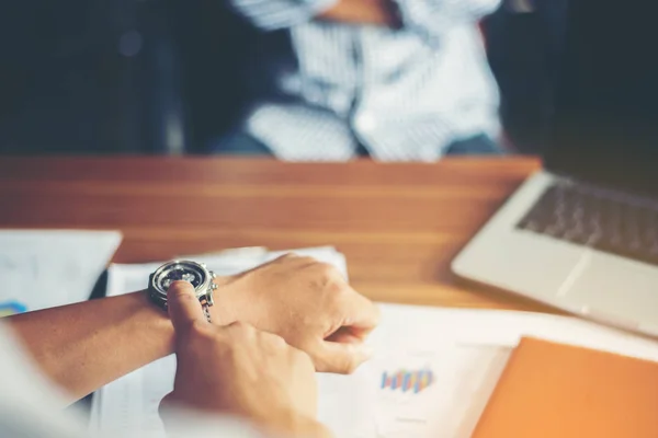 Zakenman zitten kijken zijn horloge, werken op kantoor. — Stockfoto