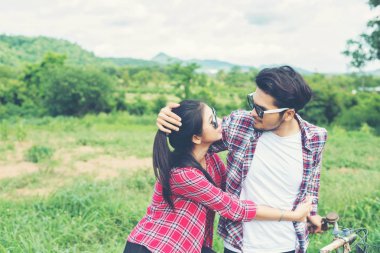 Genç hippi çift çayır relaksin üzerinde yürüme elele