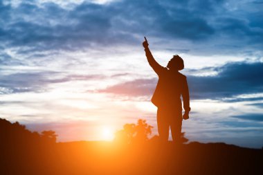 Raised arms man against beautiful sunset. clipart
