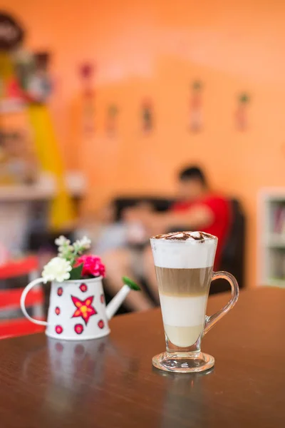 Cup of coffee with flower lobe pattern in reveal cup on wooden t