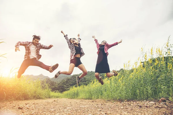 Grupo de Hipster Adolescentes Saltando no campo de flores . — Fotografia de Stock