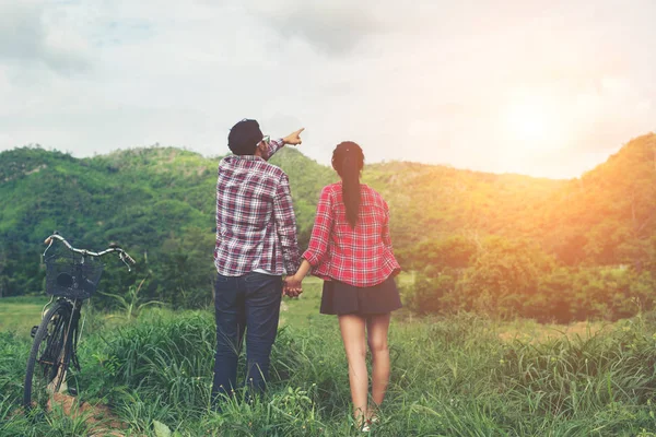 Young hipster couple holding hands walking on the meadow relaxin — Stock Photo, Image